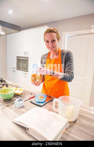 Housewife and Mother Baking Cookies for her Family and Guests. Kaatsheuvel, Netherlands. Mid adult caucasian female mixing ingredients prior to baking a fresh cake. MRYES Kaatsheuvel Hoofdstraat Noord-brabant Nederland Copyright: xGuidoxKoppesxPhotox Stock Photo