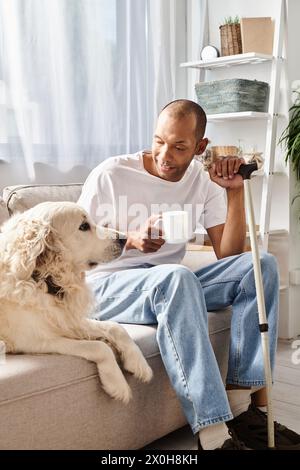 An African American man with myasthenia gravis sits next to his loyal Labrador dog on a comfy couch, enjoying a moment of peace and companionship. Stock Photo
