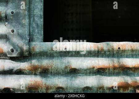 Corroded,. galvanized side of old silo with darkened opening Stock Photo