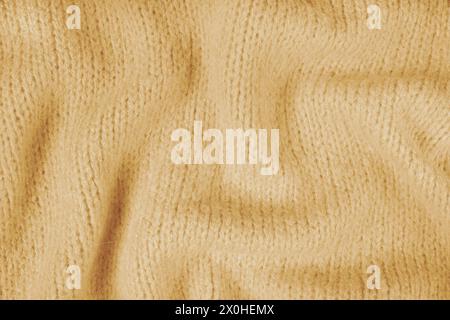 Close up background of yellow knitted fabric made of viscose yarn. Crumpled knitting wool, soft knitwear texture background. Abstract knitted wrinkled Stock Photo