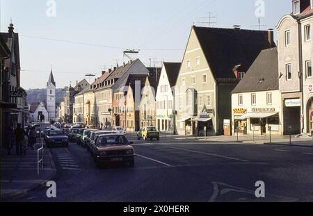Main street with houses and cars. The church of St. Leonhard in the back [automated translation] Stock Photo