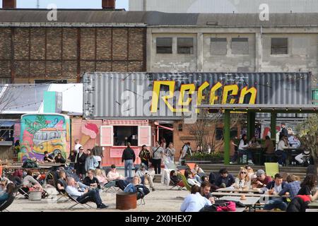 People sitting on sun loungers and at tables Refen Copenhagen Denmark April 2024 Stock Photo
