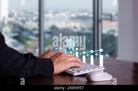 E-commerce concept. businessman's hands typing on keyboard in company office with global shopping cart hologram Stock Photo