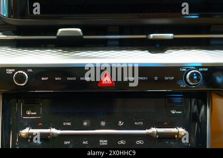 In the heart of modern automotive safety, a close-up reveals the crimson beacon of the emergency hazard light switch. Ready at a touch, this vital com Stock Photo