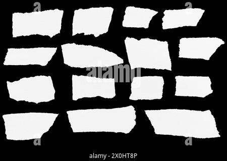 Array of various torn paper scraps with rough edges isolated on a clean black background. Assortment of different torn paper pieces with jagged edges. Stock Photo