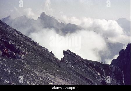 Many hikers are on the trail. The Pleisenspitze can be seen through the clouds. [automated translation] Stock Photo