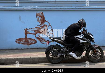 Kathmandu, Nepal. April 12, 2024: A motorcycle rider rests nearby a mural art in Kathmandu, Nepal on April 12, 2024. Artists paint a mural, showcasing Nepal's vibrant culture, tradition, portraits & festivals to decorate the walls of capital city. (Credit Image: © Sunil Sharma/ZUMA Press Wire/Alamy Live News) EDITORIAL USAGE ONLY! Not for Commercial USAGE! Stock Photo