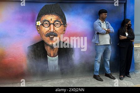 Kathmandu, Nepal. April 12, 2024: Youth rest near by a mural art in Kathmandu, Nepal on April 12, 2024. Artists paint a mural, showcasing Nepal's vibrant culture, tradition, portraits & festivals to decorate the walls of capital city. (Credit Image: © Sunil Sharma/ZUMA Press Wire/Alamy Live News) EDITORIAL USAGE ONLY! Not for Commercial USAGE! Stock Photo