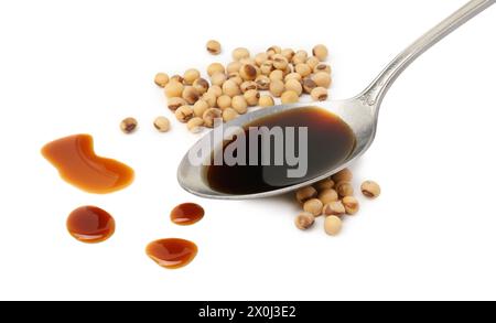 Tasty soy sauce in spoon and soybeans isolated on white Stock Photo