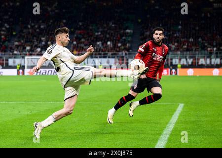 Milan, Italy. 11 April 2024. Stephan El Shaarawy of AS Roma is challenged by Theo Hernandez of AC Milan during the UEFA Europa League quarter-final first leg football match between AC Milan and AS Roma. Nicolò Campo/Alamy Live News Stock Photo