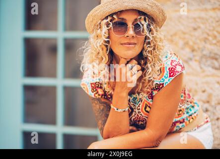 Portrait of pretty middle age female people smiling and looking on her side outside home. Attractive trendy woman tourist having relax leisure time outdoor in the town street. Cheerful adult lady Stock Photo