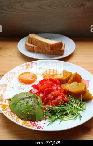 Healthy breakfast dish of sunny-side up with microgreen and avocado salad Stock Photo