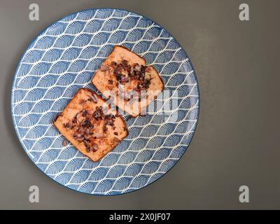 Two slices of Leberkäse with roasted onions on a plate Stock Photo