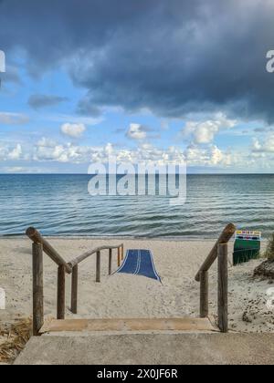 Germany, Mecklenburg-Western Pomerania, Prerow, cloud formation on the beach of the Baltic Sea coast, way to the sea, thunderstorm atmosphere with dark clouds Stock Photo