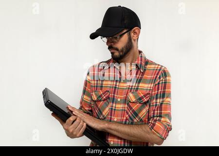 Latin American man with his laptop computer is a programmer and specializes in web development. Stock Photo