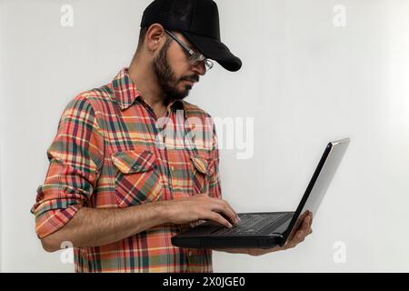 Latin American man with his laptop computer is a programmer and specializes in web development. Stock Photo