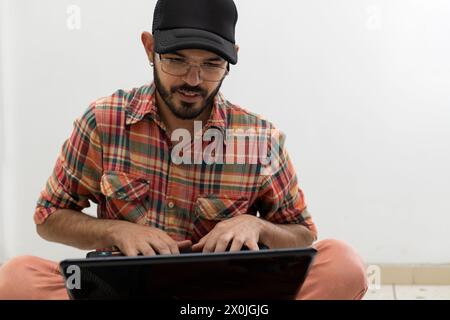 Latin American man with his laptop computer is a programmer and specializes in web development. Stock Photo