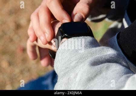 Young man setting up his smart watch to practice sport Stock Photo