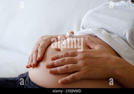 Pregnant woman with a pacifier on her belly expecting her baby Stock Photo