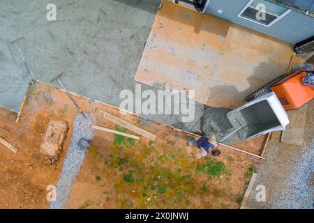 Concrete buggy truck is used to pour wet cement into framework during foundation construction Stock Photo