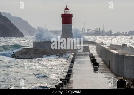 The red lighthouse of the Christmas dock on the breakwater for defense against the southeast wind of the bay in the port of Cartagena, Spain, Europe Stock Photo