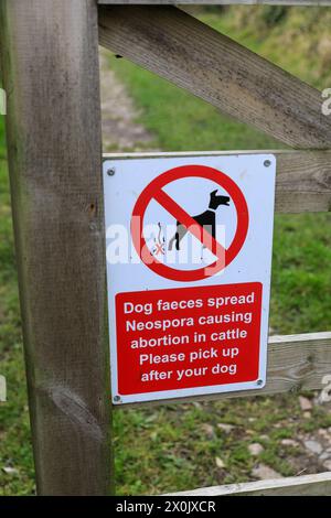 A sign saying 'Dog faeces spread Neospora causing abortion in cattle. Please pick up after your dog', England, UK Stock Photo