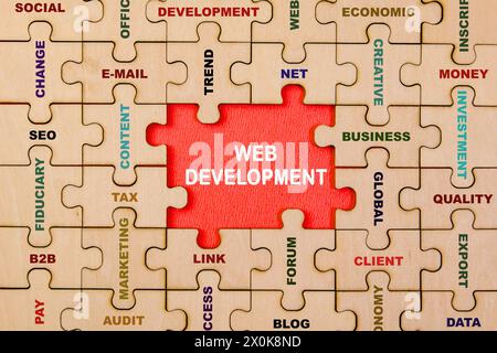 A conceptual image representing the collaborative process of web development, with puzzle pieces forming the phrase "WEB DEVELOPMENT". Stock Photo