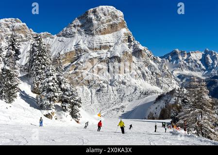 Skiers on a slope in the winter sports resort of Colfosco, Colfosco, at the foot of the Sassongher peak in the Alta Badia ski area, Dolomites, South Tyrol, Italy Stock Photo