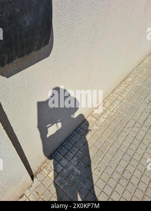 Shadow of a woman with a hat on the sidewalk, summer vacation in Mallorca, Spain Stock Photo