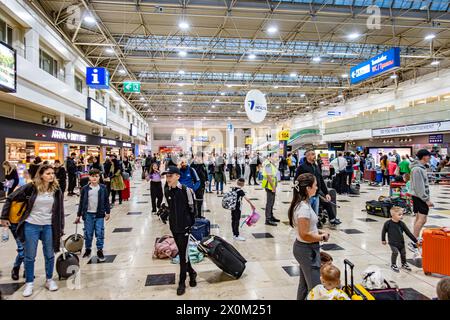 The baggage hall at Antalya Airport in Turkey, busy with passengers collecting their luggage Stock Photo