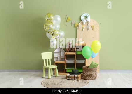 Interior of children's room with bunch of balloons, festive bunting and toys Stock Photo