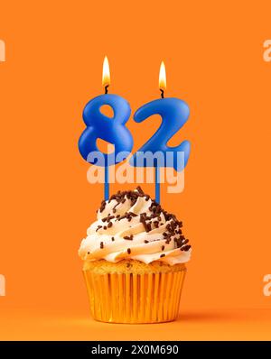 Blue birthday candle and cupcake - Number 82 Stock Photo