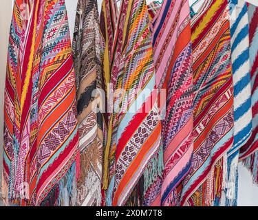 Collection of handmade Peruvian alpaca wool ponchos with traditional incas designs at the Indian market in Lima, Peru Stock Photo