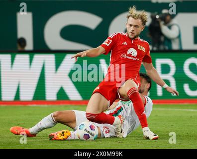 Augsburg, Germany. 12th Apr, 2024. Benedict Hollerbach (front) of Union Berlin vies with Maximilian Bauer of Augsburg during the German first division Bundesliga football match between FC Augsburg and Union Berlin in Augsburg, Germany, April 12, 2024. Credit: Philippe Ruiz/Xinhua/Alamy Live News Stock Photo