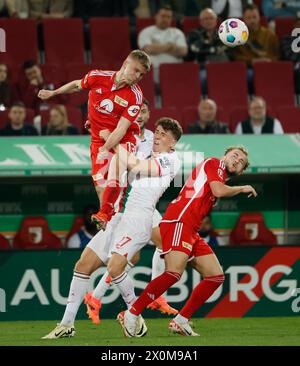 Augsburg, Germany. 12th Apr, 2024. Andras Schaefer (top) of Union Berlin vies for a header during the German first division Bundesliga football match between FC Augsburg and Union Berlin in Augsburg, Germany, April 12, 2024. Credit: Philippe Ruiz/Xinhua/Alamy Live News Stock Photo