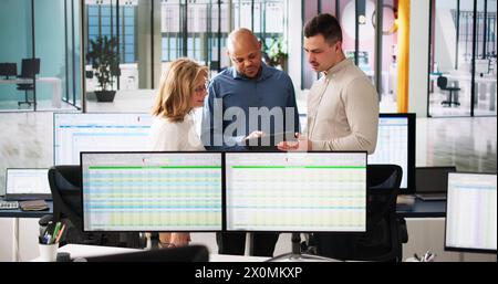 People Working With Spreadsheet Data On Computer Monitor Stock Photo