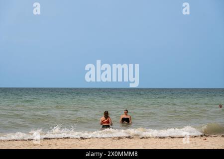Tourists and locals enjoy a spring day at Progreso Beach, a more tranquil and laid-back atmosphere compared to the bustling resort city of Cancun. Stock Photo