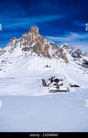 Aerial view on the snow-covered Giau pass with the Hotel Passo Giau in winter, the summit of Ra Gusela in the distance. Stock Photo