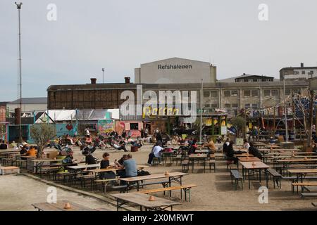 People sitting on sun loungers and at tables Refen Copenhagen Denmark April 2024 Stock Photo
