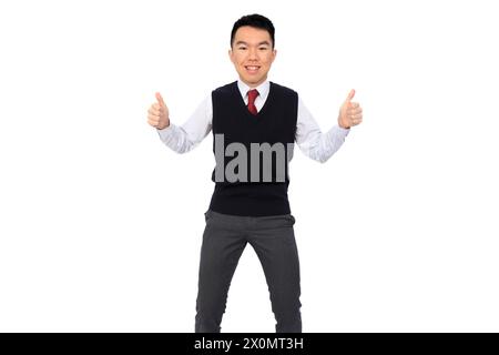 A young Asian high school student is grinning with thumbs up. He is wearing a black sweater vest over a white shirt and red tie. The background is whi Stock Photo