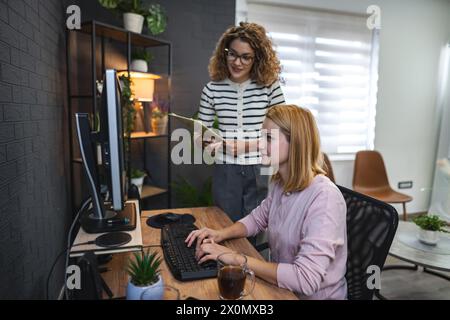 Two Women Working on a Computer in an Office Stock Photo