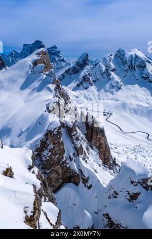 Aerial view on the snow-covered Giau pass from Mt. Nuvolau in winter, the snow-covered summits of Ra Gusela, Mt. Pelmo and Mt. Cernera in the distance Stock Photo