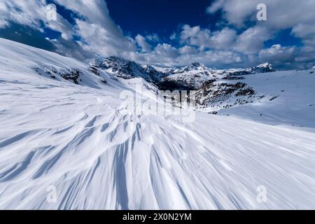 Snowdrift creating artful structures in Tre Cime Natural Park in winter, the summits of Monte Cristallo and Croda Rossa d‘Ampezzo in the distance, see Stock Photo