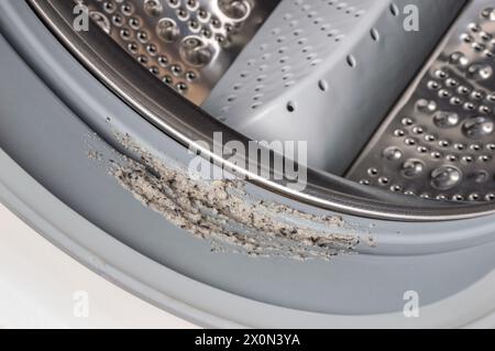 Dirty moldy washing machine sealing rubber and drum close up. Mold, dirt and limescale in washing machine. Home appliances periodic maintenance. Stock Photo