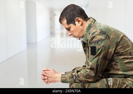 Shot of a soldier sitting on a bench in the hall of a military academy Stock Photo