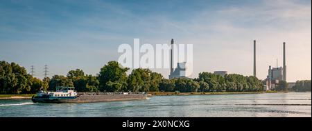 View upstream of the Rhine with ships and the steam power plant in Karlsruhe, Baden-Wuerttemberg, Germany Stock Photo