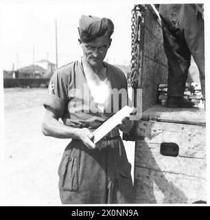 PHOTOGRAPHS TAKEN TO ILLUSTRATE OBSERVER STORIES BY CAPT. SHEARER - Cpl. Emslie of 779 Great Northern Road, Woodside, Aberdeen, Scotland, handling a slab of lead at the Salvage Dump. (Observer Story No.93). Photographic negative , British Army Stock Photo