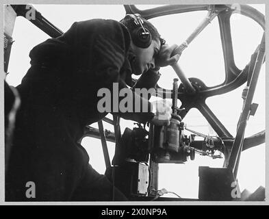 DEFEATING GERMANY'S KEY WEAPON : LIBERATOR v. U-BOAT - For story see CH.9576 (Picture issued 1943) One of the crew of a Liberator on patrol - keeping watch for the convoy. Photographic negative , Royal Air Force Stock Photo