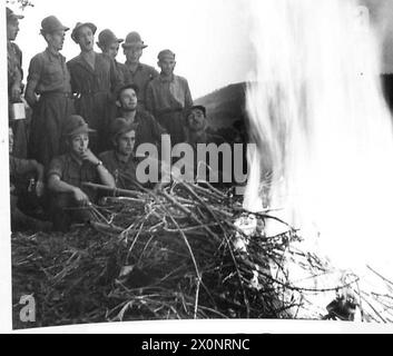 INVASION OF ITALY : EIGHTH ARMY FRONT ITALIAN TROOPS FIGHT BESIDE THE ALLIES - Men of an Italian Regiment signing marching songs around the camp fire. Photographic negative , British Army Stock Photo