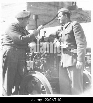 RELIEF FOR YUGOSLAVIA - The UNRRA official for agriculture checks over the tractors with his Yugoslav counterpart. W/Cmdr. W. Innes, BSC, AVD. of Canada with Engineer Joze Berkopez, Yugoslav lieutentant in charge of agricultural liaison. W/Cmdr. Innes fought in the last war, and has since been Deputy Minister of Agriculture, Province of Nova Scotia. Photographic negative , British Army Stock Photo